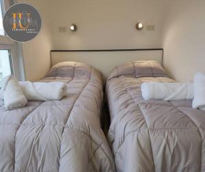 dos camas sentadas una al lado de la otra en una habitación en Monotower Ushuaia en Ushuaia
