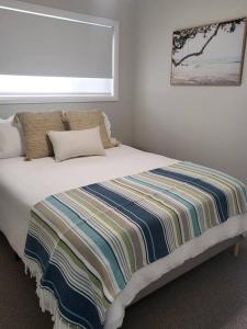 a bed with a colorful blanket on it in a bedroom at Coastal Pod in Port Macquarie