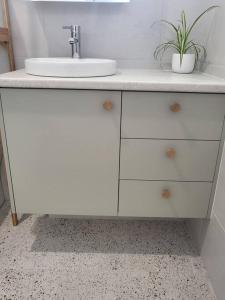 een badkamer met een wastafel en een wit aanrecht bij Coastal Pod in Port Macquarie