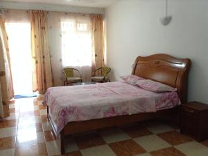 um quarto com uma cama e duas cadeiras em Ebrahim Flats - Grand Baie Beach em Grand Baie