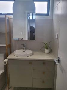 a bathroom with a sink and a mirror at Coastal Pod in Port Macquarie