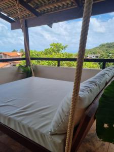 a bed on a porch with a view at Condomínio Harmonia in Pipa