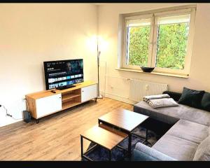 a living room with a couch and a flat screen tv at City Apartment Duisburg Netflix &Wlan & Kingsize Bett & Big TV & Central in Duisburg