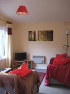 KirkhillにあるSatchwell Chalet on Reelig Estate - Dog Friendlyのベッドルーム1室(赤い枕のベッド2台付)