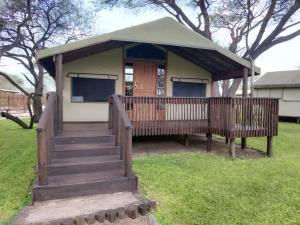 a small house with a porch and a deck at Nako Okavango Guesthouse in Ntabis