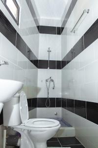 La salle de bains est pourvue d'une douche et de toilettes. dans l'établissement Baig's Guest House, à São Tomé