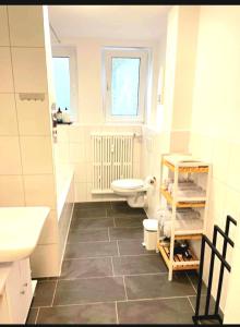 Baño blanco con aseo y lavamanos en City Apartment Duisburg Netflix &Wlan & Kingsize Bett & Big TV & Central, en Duisburg