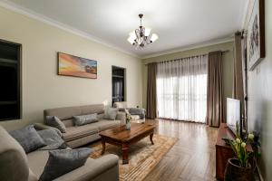 ein Wohnzimmer mit einem Sofa und einem Tisch in der Unterkunft Delightful house Kampala Entebbe in Buzzi