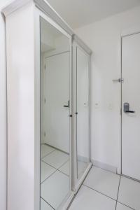 una puerta de cristal en un baño con azulejos blancos en SanLoft Expo Inn Tietê 03 Top 1 en São Paulo