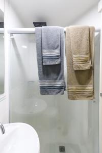 three towels hanging on a towel rack in a bathroom at SanLoft Expo Inn Tietê 03 Top 1 in Sao Paulo