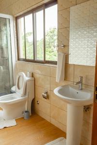 a bathroom with a toilet and a sink at Baig's Guest House in São Tomé
