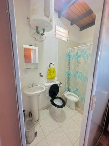 La salle de bains est pourvue d'un lavabo, de toilettes et d'une douche. dans l'établissement Departamento monoambiente para 4 personas, à Rivadavia