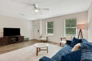 a living room with a blue couch and a tv at Modern home with garage near town in Saint Augustine