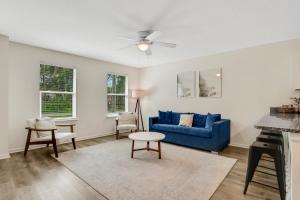 a living room with a blue couch and a table at Modern home with garage near town in Saint Augustine