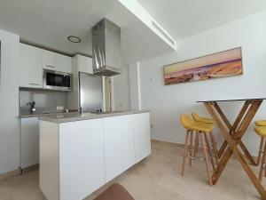 Una cocina con gabinetes blancos y un microondas y una mesa. en Magallanes Viewpoint, en Tarifa