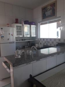 a kitchen with a counter and a sink and a refrigerator at Aconchego do velho chico in Piranhas
