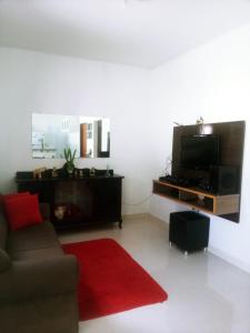 a living room with a couch and a flat screen tv at Aconchego do velho chico in Piranhas +1 photo