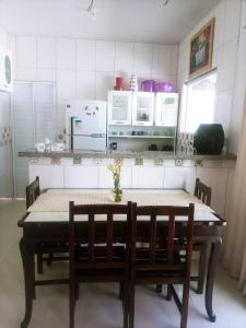 a kitchen with a table and two chairs and a counter at Aconchego do velho chico in Piranhas