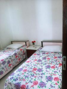 twee bedden naast elkaar in een slaapkamer bij Aconchego do velho chico in Piranhas