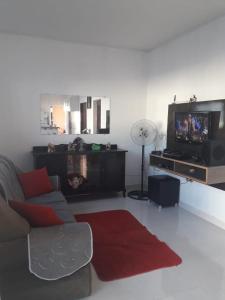 een woonkamer met een bank en een flatscreen-tv bij Aconchego do velho chico in Piranhas