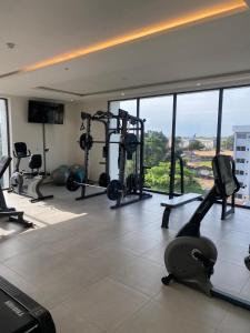 - une salle de sport avec plusieurs tapis de course et une grande fenêtre dans l'établissement Cantonments Luxury Condo and Apartment in Accra - FiveHills homes, à Accra