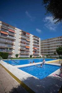 einem Pool vor einem großen Gebäude in der Unterkunft PISO Reformado Moderno Piscina y Jardín! in Salou