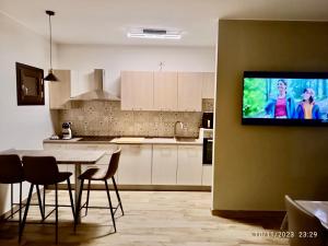 a kitchen with a table and a tv on a wall at Appartamento Relax nelle Vicinanze delle Terme in Monsummano