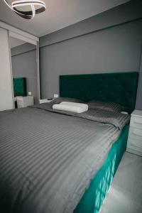 Schlafzimmer mit einem großen Bett mit einem grünen Kopfteil in der Unterkunft PISO Reformado Moderno Piscina y Jardín! in Salou