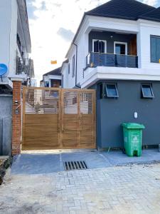 a wooden fence in front of a house at IVYs 4 Bedroom Luxury Entire Apartment Duplex with Wifi in Lekki in Ibeju