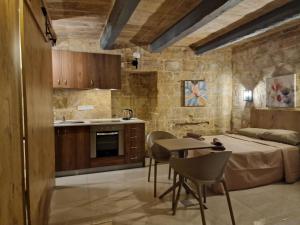 eine Küche und ein Schlafzimmer mit einem Bett und einem Tisch in der Unterkunft Renovated 16th Century House in Valletta in Valletta