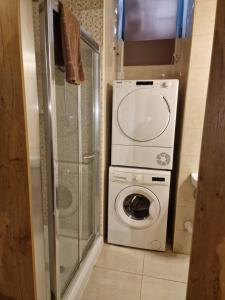 ein kleines Bad mit einer Waschmaschine und einer Dusche in der Unterkunft Renovated 16th Century House in Valletta in Valletta