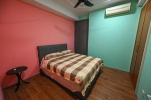 Santubong Suites Lower Level في كوتشينغ: غرفة نوم مع سرير في غرفة مع جدران ملونة