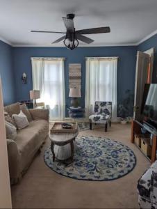 sala de estar con sofá y ventilador de techo en Sunny & Spacious Montclair NJ Apartment, en Montclair