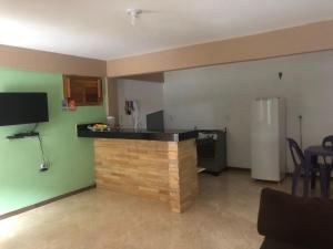 a kitchen with a bar in a living room at Casa Refúgio Familiar in Guaramiranga