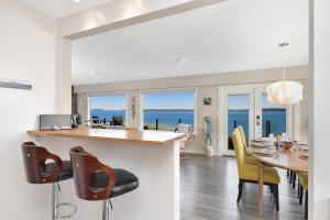 a kitchen and dining room with a view of the ocean at Bazan Bay Beach House in North Saanich