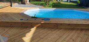 een zwembad op een houten terras met een honkbalknuppel bij Villa HAVA in Anse-Bertrand
