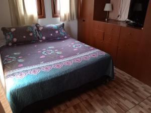 1 dormitorio con 1 cama con manta morada en La casa di Gio, en Santiago