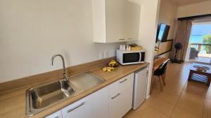 a kitchen with a sink and a microwave on a counter at Resort Tava'e in Amuri