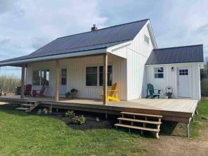 a tiny house with a porch and a deck at The Galloway House in Hillsborough
