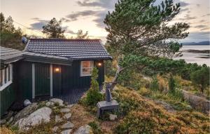 een klein huis met een bankje ervoor bij Cozy Home In Kjrsvikbugen With Wifi 