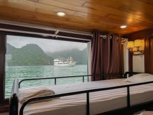 una camera da letto con vista su una barca in acqua di New Way Hotel a Cat Ba