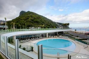 - un bâtiment avec une piscine à côté de la plage dans l'établissement Hotel Nacional, à Rio de Janeiro
