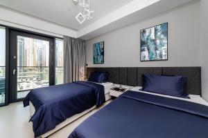 een slaapkamer met 2 bedden en een raam bij Luxurious 2BR apt with panoramic Marina view in Dubai