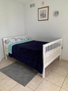 a white crib with a blue blanket on it at Ocean Reserve in Sunny Isles Beach