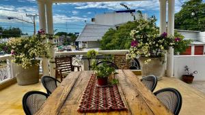 a wooden table on a balcony with potted plants at suites Casa Blanca in Ciudad Valles