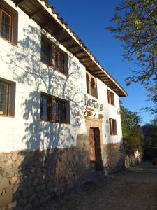 a white building with a sign on the side of it at Inka Tambo Hacienda in Cusco