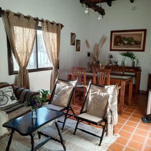 een woonkamer met een tafel en stoelen bij La Posada de los Vallistos - Casa de Campo en El Mollar Chicoana 