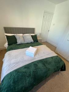 um quarto com uma cama grande e um cobertor verde em Seaforth Apartments 2 Bedroom Apartment with Parking and Garden by RockmanStays em Southend-on-Sea