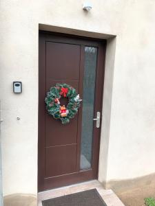 Eine braune Tür mit einem Weihnachtskranz drauf. in der Unterkunft Gîte au cours d’eau in Le Hohwald