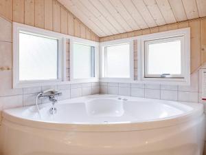 een groot wit bad in een badkamer met 2 ramen bij 10 person holiday home in Fjerritslev-By Traum in Fjerritslev +45 foto's